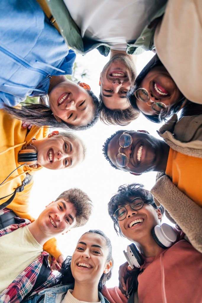 Young student friends having fun hugging together and looking to